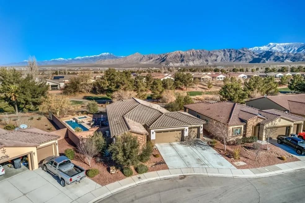 Luxury backyard featuring a swimming pool, spa, and mountain backdrop