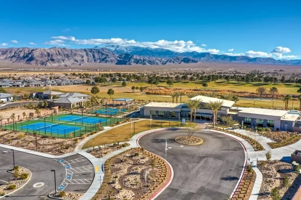 Community clubhouse entrance with tennis courts and mountain views